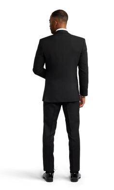 A slim black tuxedo with one button and a slightly rounded notch lapel. Black Tuxedo With Hidden Button Closure For Party, Black Tie Single Button Blazer With Notch Lapel, Tailored Notch Lapel Tuxedo With Single Button, Tailored Single Button Tuxedo With Notch Lapel, Notch Lapel Single Button Blazer For Black Tie, Single Button Notch Lapel Blazer For Black Tie, Black Tie Tuxedo Blazer With Hidden Button Closure, Tuxedo Blazer With Hidden Button Closure For Black Tie, Tuxedo With Hidden Button Closure And Notch Lapel