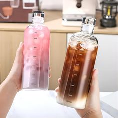 two people holding up bottles with drinks in them