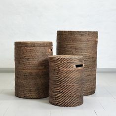 three woven baskets sitting on top of a white floor