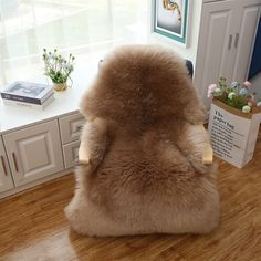 the back of a chair with a fur covering on it in front of a window