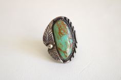 "This Native American ring features a large green turquoise stone in a large statement setting. The ring is in good condition with natural aged patina. Turquoise stone has an inclusion that is natural to the stone. Ring is signed \"B Sterling\" - possible Benjamin Piaso Navajo. Please checkout the similar turquoise stone cuff - different artisan - (ring and cuff are listed separately). size 7 1/2 1 5/8 inch tall 1 3/16 inch wide band is 1/2 to 3/4 inch thick I ship worldwide! Thanks for looking. Vintage Chrysocolla Turquoise Ring, Bohemian Turquoise Ring With Patina For Collectors, Antique Turquoise Ring With Patina, Vintage Green Turquoise Ring With Inlay, Turquoise Statement Ring, Contemporary Costumes, Native American Rings, Artisan Rings, Basic Jewelry