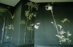 the wall is painted green with white flowers and bamboo branches on it, along with dark wood paneling