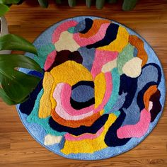 a colorful rug on the floor next to a potted plant