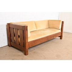 a wooden couch sitting on top of a cement floor