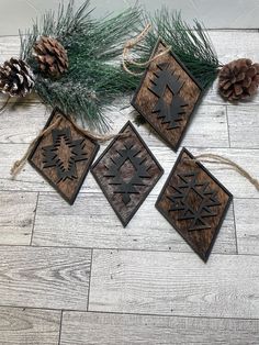 three wooden ornaments with pine cones on the floor