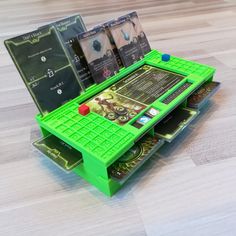 a green table that has some cards on top of it and is sitting on the floor