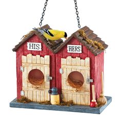 a bird sitting on top of a red and white birdhouse with two doors that say his and hers