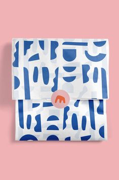 a blue and white patterned envelope on a pink background