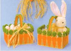 two stuffed animals sitting in small baskets with grass and flowers on the sides, one is holding an easter egg