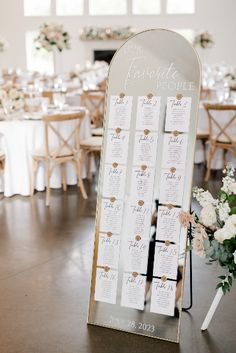 a wedding seating chart is displayed on an easel in the middle of a room