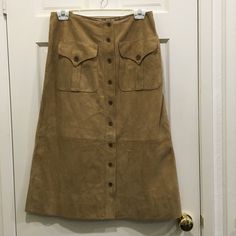 Ralph Lauren Black Label Tan Suede A Line Skirt Size 8 9 Buttons Used To Close Front Of Skirt 2 Large Pockets With Buttoned Flaps In Upper Front Skirt 15 1/2” Waist 20” Hips 29” Length From A Smoke Free And Dog Loving Home Indented Small Area From Plastic Hanger Near Waist, Otherwise In Excellent Condition, Never Worn. Belts Cover It, Cleaners Can Try Steaming, Maybe Time It Will Disappear, Hope So! Use The Two Tie Loops Provided To Prevent Future Pressure Fitted Brown Maxi Skirt For Workwear, Fitted Long Skirt With Button Closure, Brown Fitted Full Length Skirt, Full Length Brown Relaxed Fit Skirt, Brown Full Length Skirt, Tan Suede Skirt, Ralph Lauren Black Label, Plastic Hangers, Suede Skirt