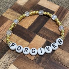 Adorable "forgiven" christian bracelet available in multiple sizes. Adjustable Personalized Gold Crystal Bracelet, Inspirational Adjustable Gold Charm Bracelet, Gold Crystal Bracelet With Round Beads For Friendship, Gold Personalized Spiritual Beaded Bracelets, Personalized Gold Spiritual Bracelet, Personalized Spiritual Gold Bracelet, Gold Spiritual Bracelets With Letter Beads, Gold Spiritual Bracelet With Letter Beads, Gold Rosary Bracelet With Letter Beads As Gift