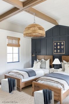 two twin beds in a bedroom with blue walls and white carpeted flooring, one has a wicker basket hanging from the ceiling