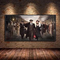 a large poster hanging on the wall in an empty room with wooden flooring and brick walls