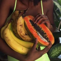 a woman holding a bunch of watermelon and bananas