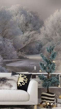 a white couch sitting in front of a wall with trees and snow on the ground