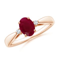 a yellow gold ring with an oval ruby stone and two diamonds