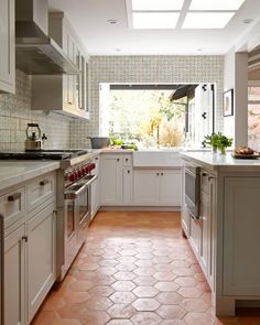 a kitchen with white cabinets and tiled flooring