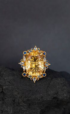 Statement ring with a huge natural yellow citrine framed in intricate lace of blue sapphire and topaz ! It's so stunning on a hand, you will fall in love with it :) ♥ The ring in the video is in size 6 US, the model has rather small hands :) ♥ The design can be made with gemstones of your choosing ♥ Each order will be gift wrapped beautifully ♥ QUALITY: Each item is stamped according to US regulations.  ------   *DIMENSIONS*  ------ ♥ Ring Size: All sizes will be made to order Main Metal: 925 St Luxury Yellow Sapphire Ring, Luxury Yellow Sapphire Jewelry With Accent Stones, Luxury Yellow Topaz Ring With Diamonds, Luxury Yellow Sapphire Ring For Anniversary, Luxury Yellow Sapphire Anniversary Ring, Exquisite Gold Topaz Ring With Prong Setting, Elegant Yellow Sapphire Ring With Prong Setting, Luxury Yellow Sapphire Jewelry, Luxury Citrine Topaz Ring With Accent Stones