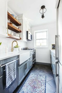 a kitchen with white cabinets and blue rug