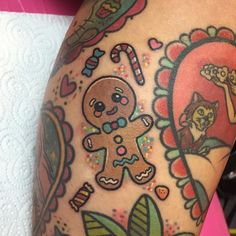 a close up of a person's leg with tattoos on it and an image of a gingerbread man