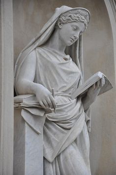 a statue of a woman holding a book