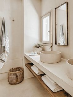 a white bathroom with two sinks and towels on the counter next to eachother