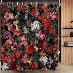 the shower curtain is decorated with colorful flowers and leaves on a black background, along with a wooden floor