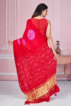 Flaunt your elegant style every day in this red bandhej Gajji silk saree with zari pallu. It comes with a matching blouse piece. Disclaimer: The shown stitched blouse on the model is for display purpose only. The saree comes with a matching blouse piece and finished with fall and piko. Red Bandhani Print Pre-draped Saree In Art Silk, Fitted Bandhani Print Saree For Navratri, Red Bollywood Choli With Bandhani Print, Fitted Bandhani Print Saree, Fitted Bandhani Print Saree For Diwali, Red Pre-draped Saree With Zari Weaving In Dola Silk, Semi-stitched Red Choli With Bandhani Print, Red Dola Silk Choli With Self Design, Red Pre-draped Saree With Zari Weaving On Dola Silk