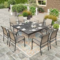 an outdoor dining table and chairs set up on a patio with potted plants in the background