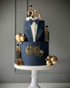 a blue and gold birthday cake with an elegant bow tie on it's top