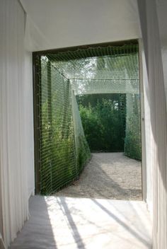 an open door leading into a lush green area with trees in the backgroud