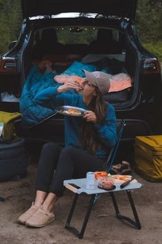 a woman sitting in the back of a car eating food