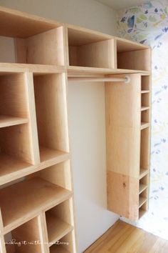 an empty closet with wooden shelving and hard wood flooring on the side wall