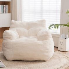 a white bean bag chair sitting on top of a rug in front of a window