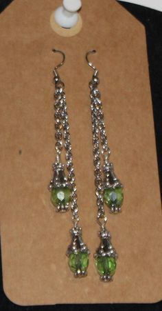 3" silver chain dangle earings with green crystal dangles Green Dangling Charms Jewelry, Green Dangle Jewelry With Dangling Charms, Green Dangle Jewelry With Charms, Green Dangle Crystal Earrings, Green Crystal Earrings For Jewelry Making, Dangle Earrings With May Birthstone In Metal, May Birthstone Dangle Earrings, Green Metal Dangle Earrings, Green Nickel Free Dangle Chandelier Earrings