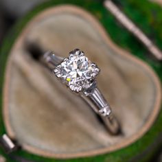 a diamond engagement ring sitting on top of a green box