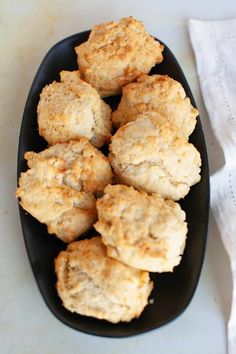 some biscuits are on a black plate next to a white napkin