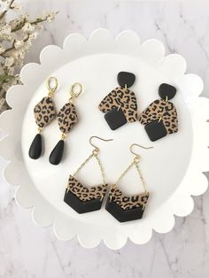 leopard print and black acrylic earrings on a white plate