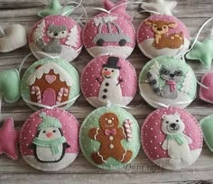 some ornaments are hanging on a wooden table with snowmen and other decorations in the shape of christmas balls