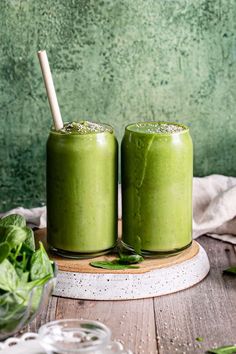 two green smoothies are sitting on a table