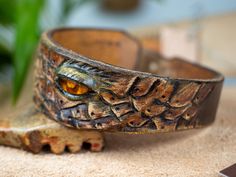 Genuine leather bracelet decorated with Baltic amber for a unique woman. This unique bracelet was made entirely by hand from a single piece of thick cowhide. dimensions: - thickness 4-5 mm - width at the widest point 3.8 cm - max inner circumference of the fastened bracelet 18.5 cm - fits wrist up to 17 cm in circumference This unique bracelet will be the best gift for your beloved woman. Leather Bangle Bracelet, Leather Bangle Bracelets As Gifts, Handmade Brown Leather Bracelet For Gift, Handmade Brown Leather Bracelet Gift, Adjustable Hand Tooled Leather Bracelet, Unique Leather Bracelet As Gift, Unique Adjustable Leather Bangle Bracelet, Unique Adjustable Bracelet With Leather Strap, Unique Brown Leather Bracelets