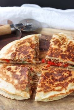 a cut in half pizza sitting on top of a wooden cutting board