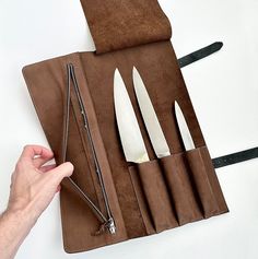 a knife case with five knives in it and a zippered pouch on the side