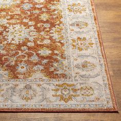 an orange and white area rug on a wooden floor with a wood floor in the background