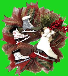 two christmas wreaths with ice skates and holly on them, against a green background