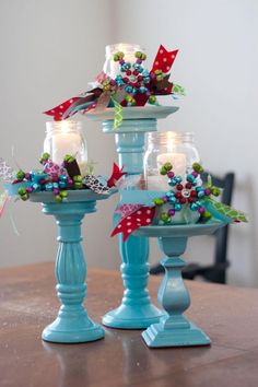 two blue candle holders with flowers and candles on them