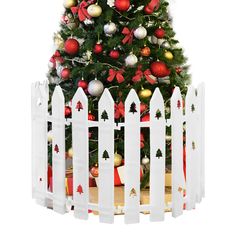 a white picket fence with a christmas tree in the center and decorations on top, all around it