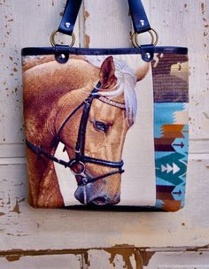 Southwest/western horse tote bag.Made from a tapestry horse panel. And Pendleton blue and brown southwest wool fabric. Bound with real black leather. And black real leather straps. Lined in a black duck cloth. The tote bag measures 22 inches from the top of the handles to the bottom of the bag. Inside the bag measures 13 across and 12 inches down. Inside the tote bag has 1 zipper pocket and 1 cell phone pocket. With a silver magnetic snap closer. Horse Tote Bag, Black Duck, Duck Cloth, Bag Inside, Western Horse, Patchwork Bags, Tote Bag Purse, Wool Fabric, Friends In Love