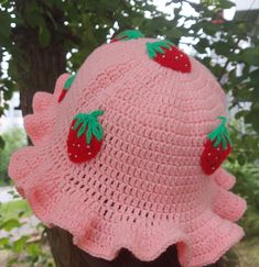 a pink crocheted hat with strawberries on it